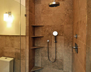 Inside the shower, more Dornbracht fixtures, including an overhead rain shower head and a second hand-held one.   An obsolete laundry chute and built-in cabinet in the original bathroom was removed, making this a spacious shower
