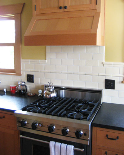 Everything in this kitchen is chosen for efficiency and compactness.  The gas stove is small but very functional.  Custom fir cabinets are used to clad everything, including the exhaust hood