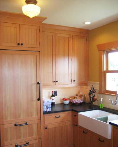 That's an extra-skinny Sub-Zero fridge behind the fir panel on the left.  The farmhouse sink with wall-mounted faucet gives the kitchen a bit of a country feel