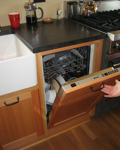 Even the Bosch dishwasher is small and disguised by a panel, so that the entire kitchen feels built-in and free of modern touches.  Note the quarter-sawn white oak floors finished with Osmo polyx oil, a green alternative to Swedish finish