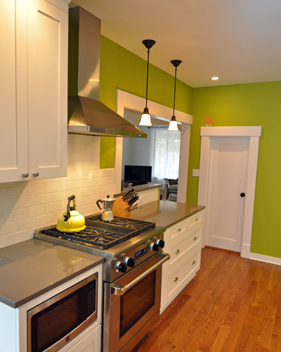 The new range and exhaust hood provide modern convenience, set off by subtle quartz counters by Pental. The range is also a huge improvement over the previous range, which sat by itself on an adjacent wall, blocking the flow of traffic. Brightly painted walls bring a pop of color to this otherwise neutral space