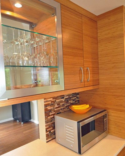 Under-cabinet lighting at the upper cabinets with glass fronts on both sides sheds light on the task counters below..  The Puc lights inside those cabinets also illuminate stemware from each room