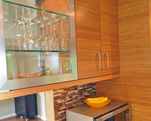 Under-cabinet lighting at the upper cabinets with glass fronts on both sides sheds light on the task counters below..  The Puc lights inside those cabinets also illuminate stemware from each room. Seattle custom kitchen cabinet