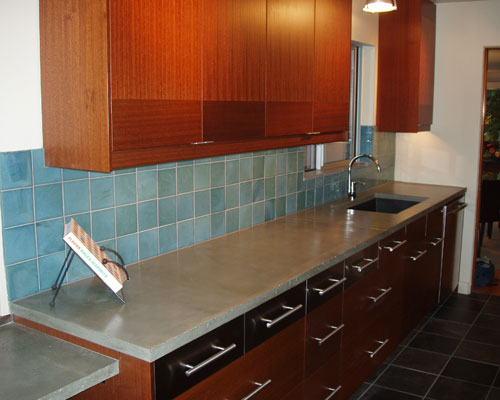 A deep single composite sink blends in because of its dark color.  A new window with a sill in the same material as the countertop helps with ventilation in the kitchen, galley kitchen Seattle