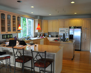 The original kitchen had white-washed wood cabinets with traditional detailing.  A peninsula cut off the flow from the dining room into the kitchen, and a squarish island added to stodgy feel.  A soffit at the south side artificially lowered the height of the cabinet tops.  From the front door, all you could see was the end of the peninsula