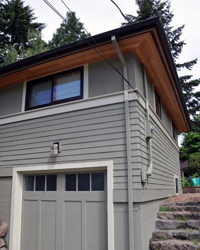 The new vented cedar soffits replace the old painted plywood soffits with striking results.   A new garage door, along with insulation and other work in the garage space change the view from the South as well.  Earthquake retrofitting was also done at the basement level wherever there was access