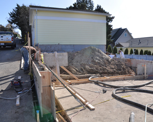 Because the property is on a hill, part of the foundation wall was high and the rest at grade.  This project also included a new slab at the garage, parking area, and new stairs to the back yard